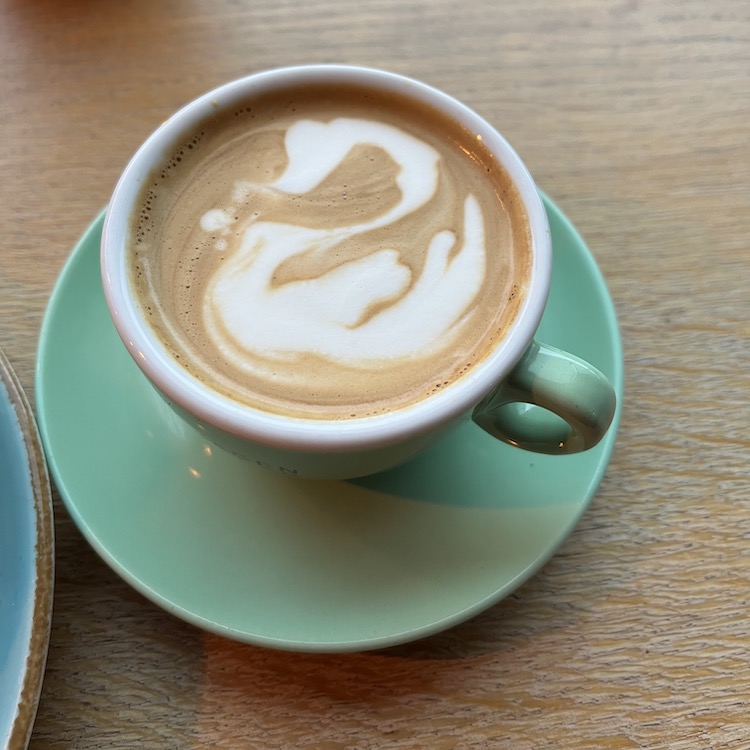 Image of a flat white with an attempt of a swan latte art